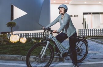 Vrouw met fietshelm op een elektrische fiets in de stad – e-bike veiligheid