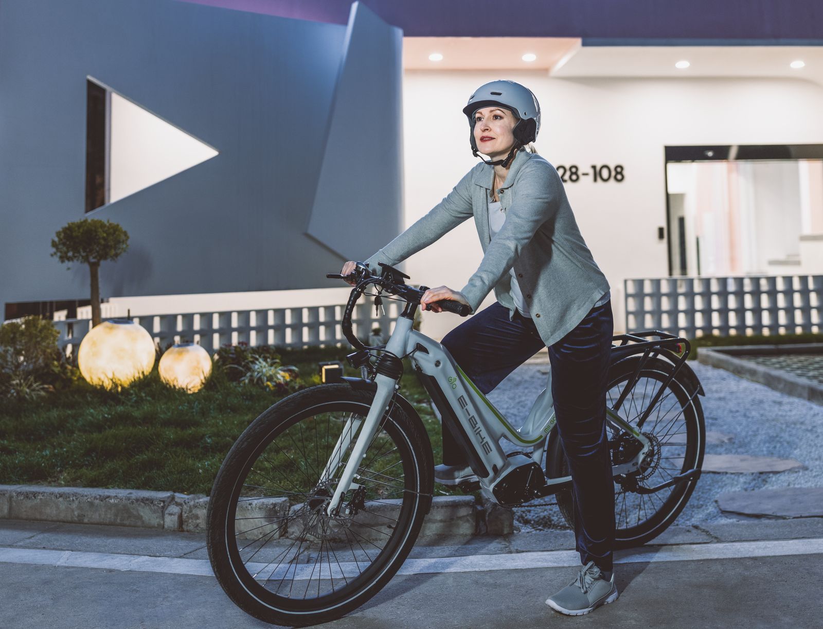 Vrouw met fietshelm op een elektrische fiets in de stad – e-bike veiligheid